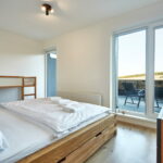 Ložnice s manželskou postelí a palandou apartmánu A1