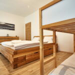 Ložnice s manželskou postelí a palandou apartmánu A1